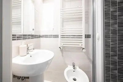 a white bathroom with a sink and a toilet at Domus Lodi Urban Stay I Affittacamere in Rome