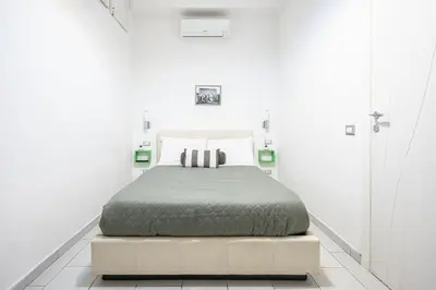 a bedroom with a bed in a white room at Domus Lodi Urban Stay I Affittacamere in Rome