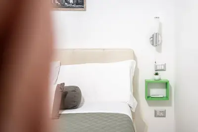 a bed with white sheets and a pillow on it at Domus Lodi Urban Stay I Affittacamere in Rome
