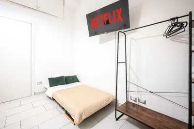 a bed in a room with a sign on the wall at Domus Lodi Urban Stay I Affittacamere in Rome