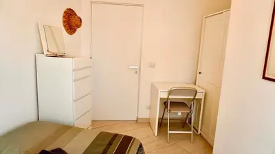 a bedroom with a bed and a desk and a refrigerator at Entire Flat at Last floor in Piazza Bologna in Rome