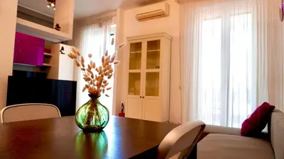 a dining room table with a vase with flowers in it at Entire Flat at Last floor in Piazza Bologna in Rome