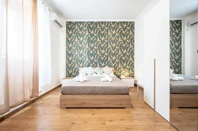 a bedroom with a bed and a wall with a wallpaper at Feel at Home I Modern Cozy Apartment in Rome