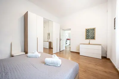 a white bedroom with two towels on a bed at Feel at Home I Modern Cozy Apartment in Rome