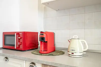 a red microwave and a coffee maker on a kitchen counter at Feel at Home I Modern Cozy Apartment in Rome