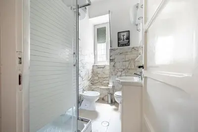 a white bathroom with a toilet and a sink at Feel at Home I Modern Cozy Apartment in Rome