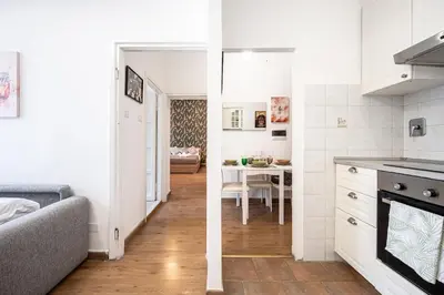 a kitchen and a living room with a table at Feel at Home I Modern Cozy Apartment in Rome