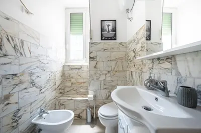 a white bathroom with a sink and a toilet at Feel at Home I Modern Cozy Apartment in Rome