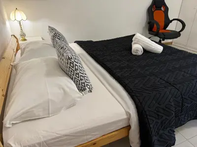 a bed with black and white sheets and pillows at RAHIMA GUEST HOUSe 2 in Rome