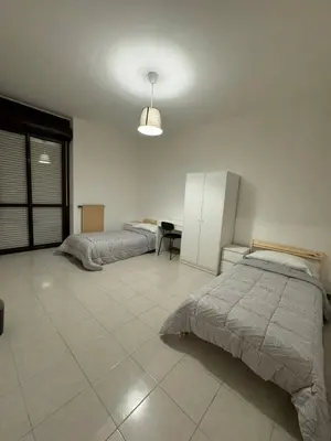 a bedroom with two beds and a table in it at RAHIMA GUEST HOUSe 2 in Rome