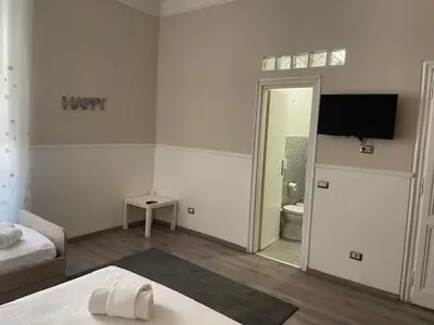 a white room with a bed and a television on the wall at the room in the museum in Rome