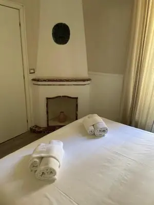 two towels on a bed in a room with a fireplace at the room in the museum in Rome