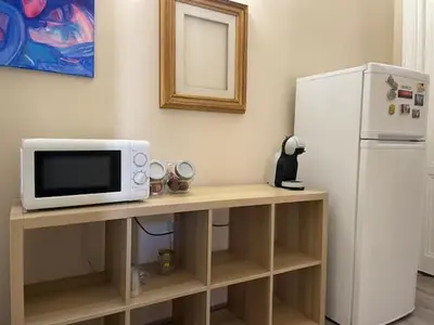 a microwave sitting on a table next to a refrigerator at the room in the museum in Rome