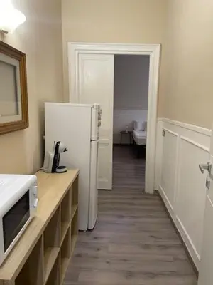 a kitchen with a refrigerator and a table with a microwave at the room in the museum in Rome