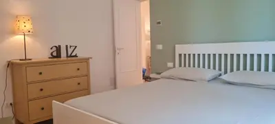 a bedroom with a bed and a dresser with a lamp at Maison Viola in Rome