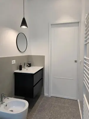 a bathroom with a sink and a mirror and a door at Maison Viola in Rome