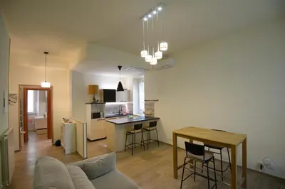 a living room and kitchen with a couch and a table at Appartamento Iris in Rome