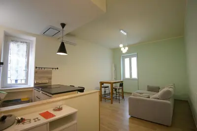 a kitchen and living room with a couch and a table at Appartamento Iris in Rome