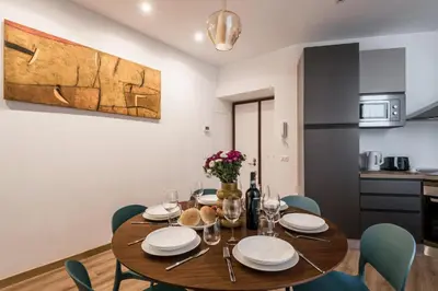 a dining room with a wooden table and chairs at The Best Rent - Three-Room Apartment with View of the Portico d'Ottavia in Rome