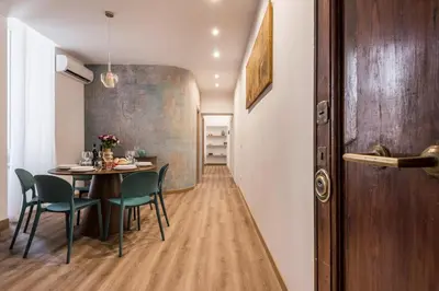a dining room with a table and chairs at The Best Rent - Three-Room Apartment with View of the Portico d'Ottavia in Rome
