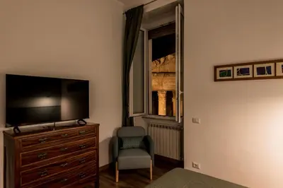 a bedroom with a tv and a chair and a dresser at The Best Rent - Three-Room Apartment near Lungotevere in Rome