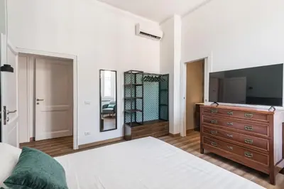 a bedroom with a bed and a dresser with a television at The Best Rent - Three-Room Apartment near Lungotevere in Rome