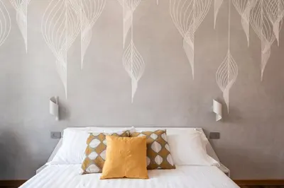 a bedroom with a bed and a wall with white feathers at The Best Rent - Three-Room Apartment near Lungotevere in Rome