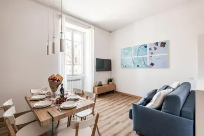 a living room with a table and a blue couch at The Best Rent - Three-Room Apartment near Lungotevere in Rome