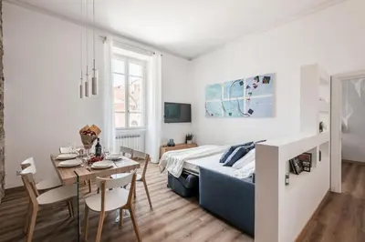 a living room with a bed and a dining table at The Best Rent - Three-Room Apartment near Lungotevere in Rome