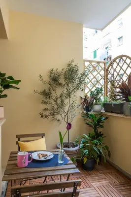 a table with a plate of food on a balcony with potted plants at MARCANTONIO HOME ROME - Vatican - in Rome