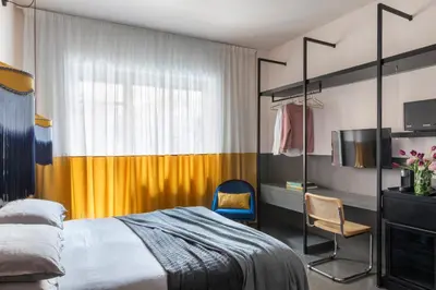 a bedroom with a bed and a tv and a chair at MARCANTONIO HOME ROME - Vatican - in Rome