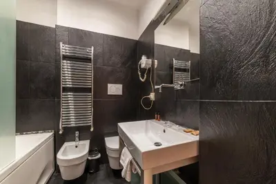a black and white bathroom with a sink and a toilet at San Marco City View Rooms in Rome
