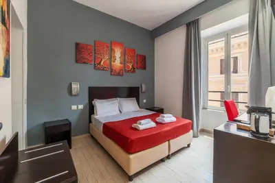 a hotel room with a bed with a red blanket at San Marco City View Rooms in Rome