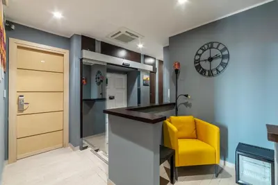 a office with a yellow chair and a clock at San Marco City View Rooms in Rome