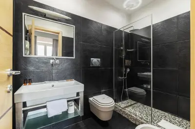 a bathroom with a sink and a toilet and a mirror at San Marco City View Rooms in Rome