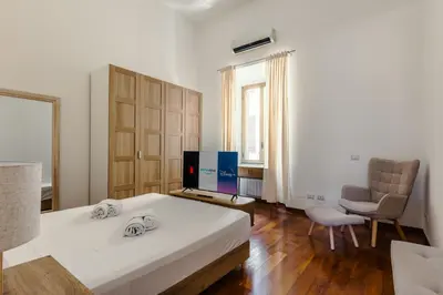 a bedroom with a bed and a chair and a television at Casa Vacanze Ottaviano 25 in Rome