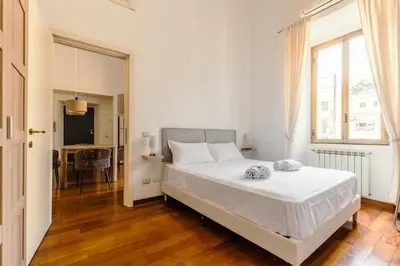 a white bedroom with a bed and a table at Casa Vacanze Ottaviano 25 in Rome