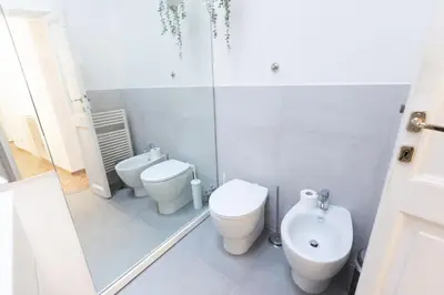 a bathroom with two toilets and a sink at 346aarome Rome Vaccarella Terrace in Rome
