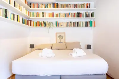 a bedroom with a white bed with bookshelves at 346aarome Rome Vaccarella Terrace in Rome
