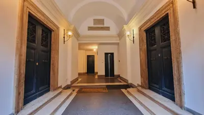 an empty hallway with two black doors and a floor at Cozy Colosseum 2BR-2BA Family Home in Rome
