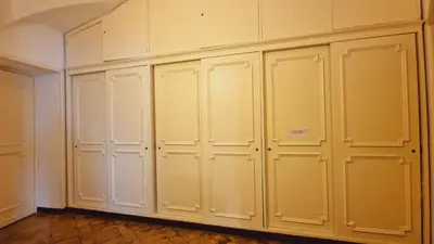 a row of white closets in a room at Cozy Colosseum 2BR-2BA Family Home in Rome