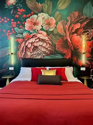 a bedroom with a red bed with a floral wallpaper at Vacanze Romane Suite 7 Languages in Rome