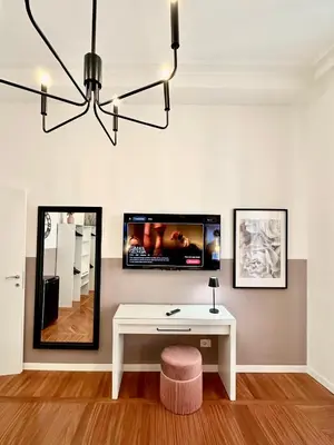 a living room with a white table and a tv at Vacanze Romane Suite 7 Languages in Rome