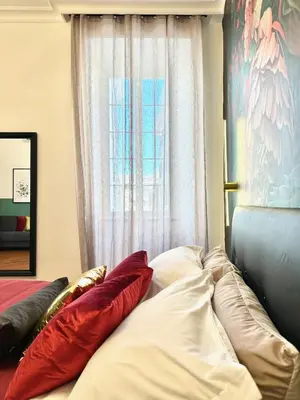 a bed with pillows sitting in front of a window at Vacanze Romane Suite 7 Languages in Rome