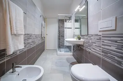 a bathroom with a sink and a toilet and a mirror at New 3BR-2 Baths Near Vatican & Metro- The Comics House in Rome