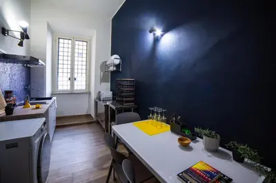a kitchen with a table and a blue wall at New 3BR-2 Baths Near Vatican & Metro- The Comics House in Rome