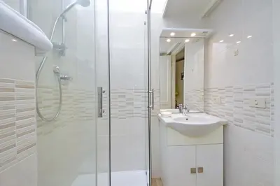 a white bathroom with a sink and a shower at Charming Nest Steps from the Vatican in Rome