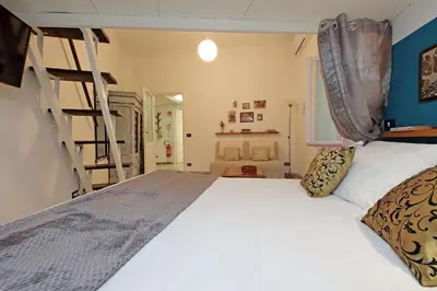 a bedroom with a large bed and a ladder at Charming Nest Steps from the Vatican in Rome