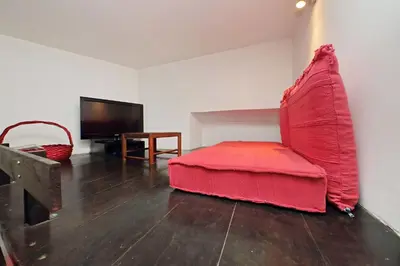 a living room with a red couch and a television at Charming Nest Steps from the Vatican in Rome