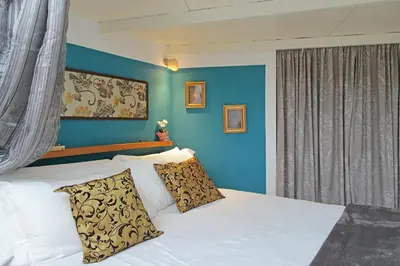 a bedroom with a white bed with a blue wall at Charming Nest Steps from the Vatican in Rome